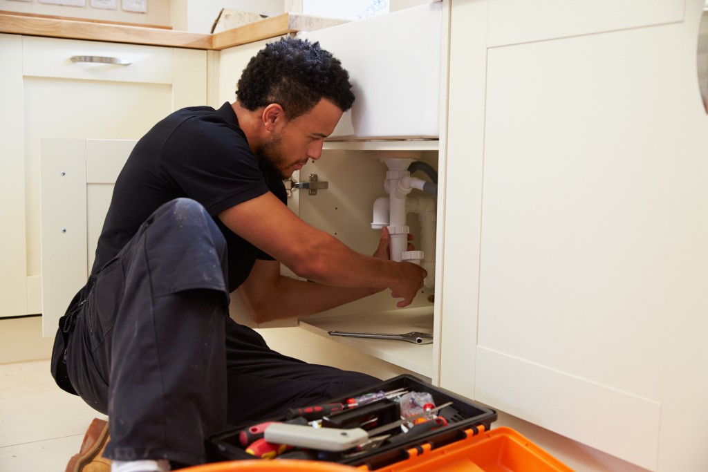 man fixing plumbing sink