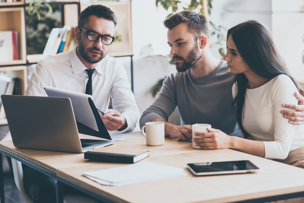Couple with an agent discussing mortgage