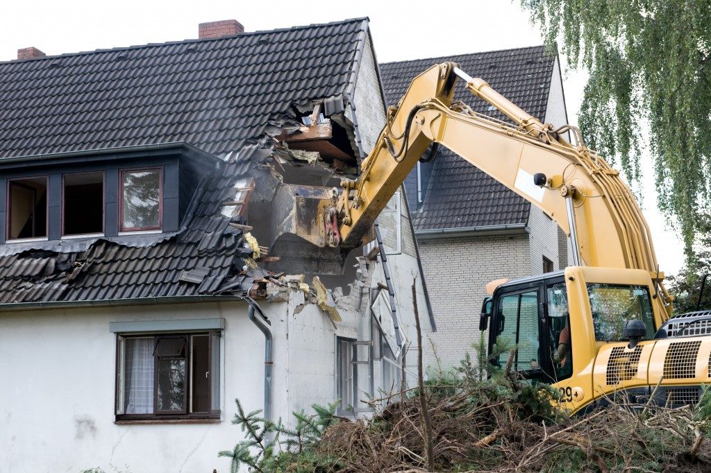 A digger demolishing houses for reconstruction