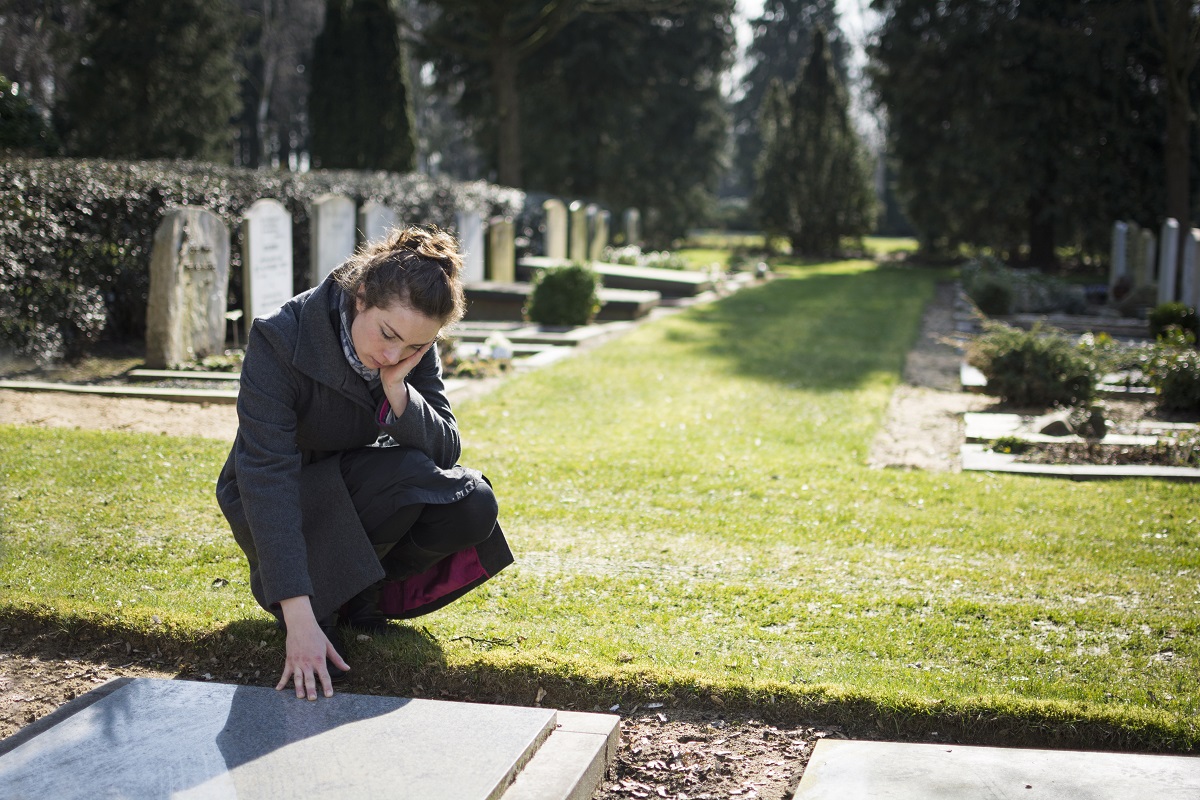 woman mourning for a loved one in the cemetery