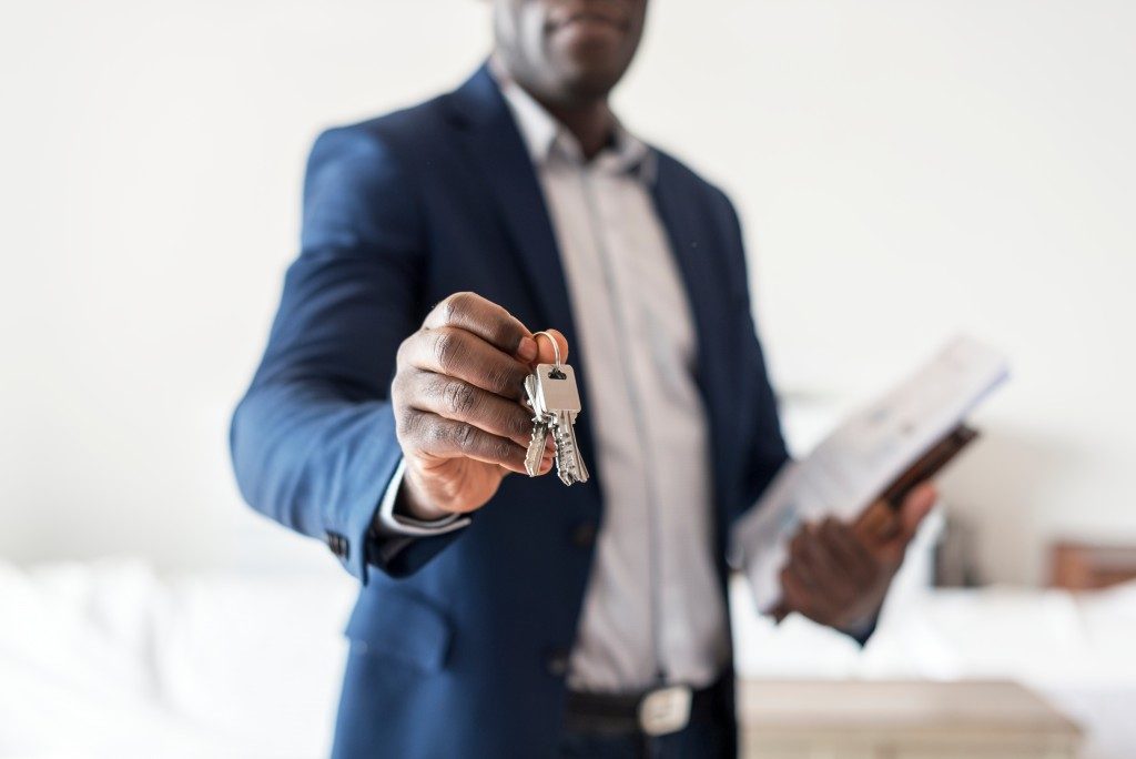 lower shot of an estate agent handing a home key