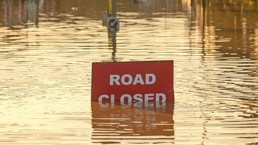 road closed sign submerged in flood