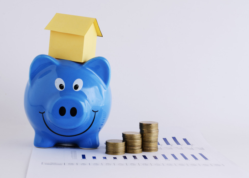 blue piggy bank with miniature house on its head